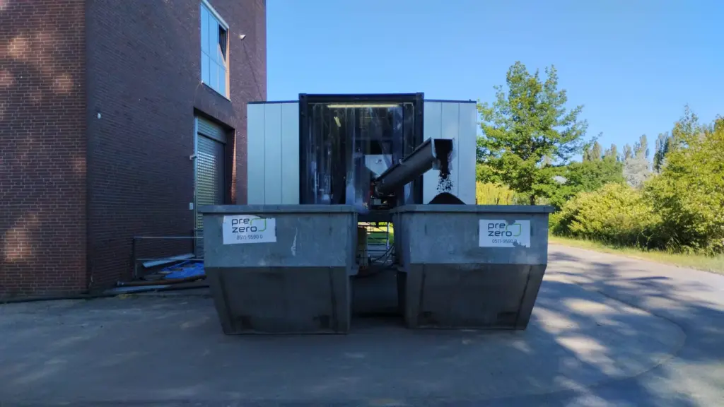 Entwässerter Industrieschlamm wird aus der mobilen MSB-Anlage in Niedersachsen im PLZ-Gebiet 382xx über ein Förderband in Mulden ausgetragen