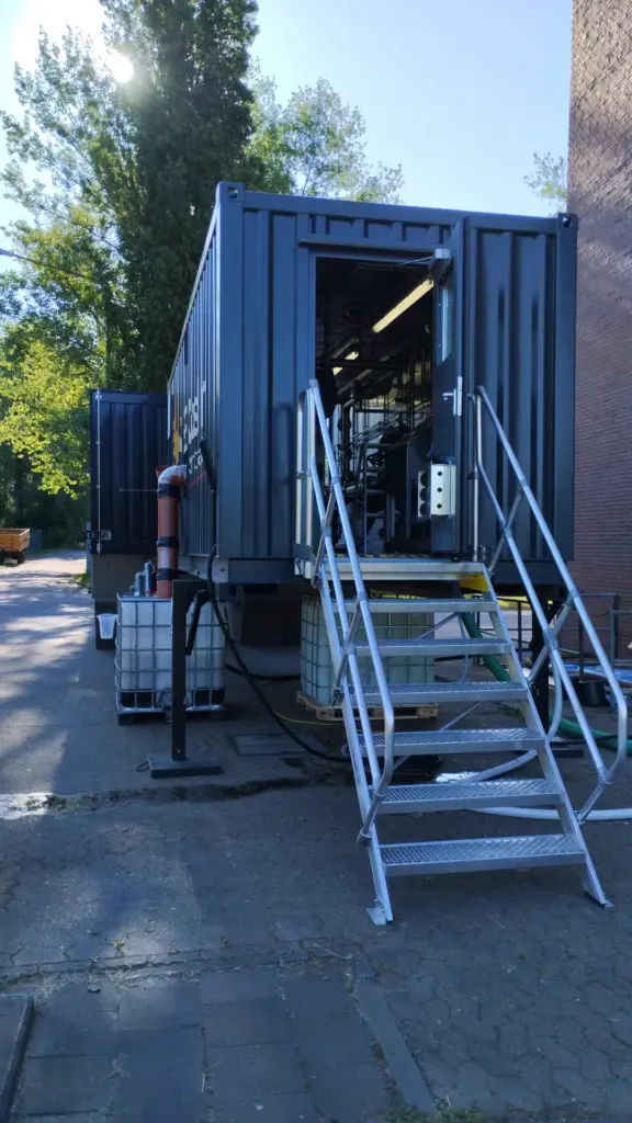 Geöffneter Zugang mit Treppe zur mobilen MSB-Containeranlage MA2 während einer Entwässerungskampagne in Niedersachsen im PLZ-Gebiet 382xx